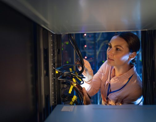 Caucasian female engineer inspecting the server in computer server room. database server management and maintenance concept