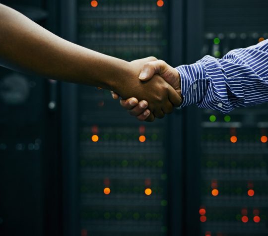Paired up for professional IT service. Cropped shot of two men shaking hands in a data center